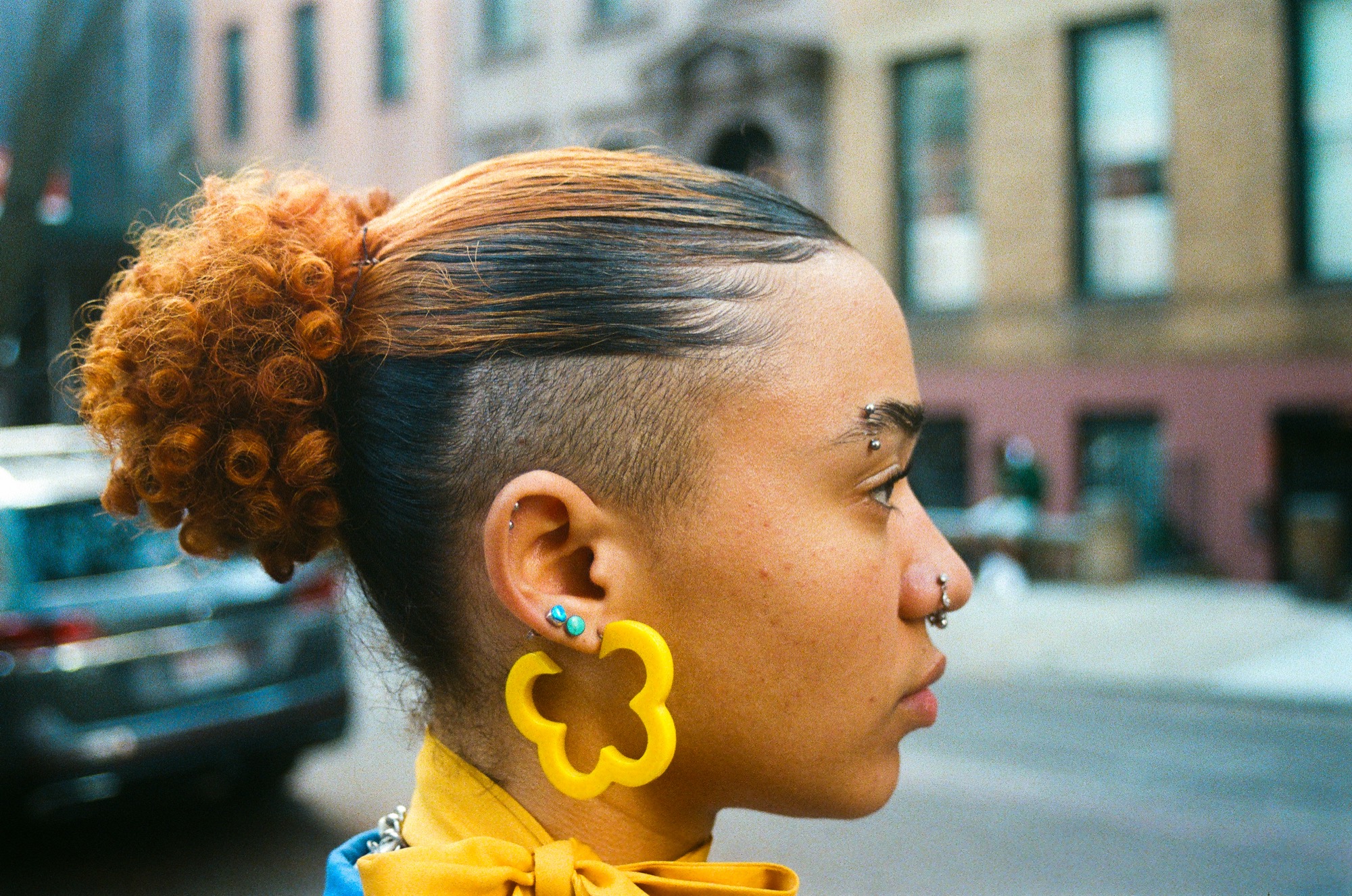 Profile portrait — orange hair and a yellow floral earring