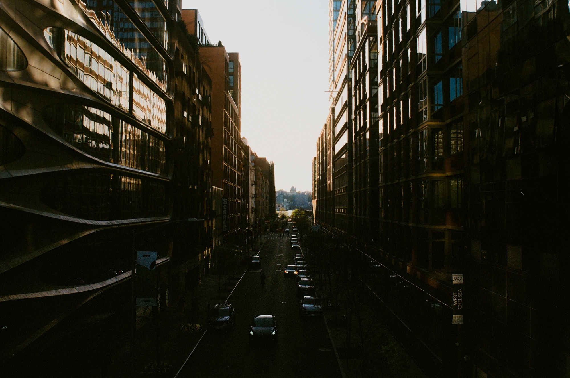 Golden-hour street framed between glass buildings, New York