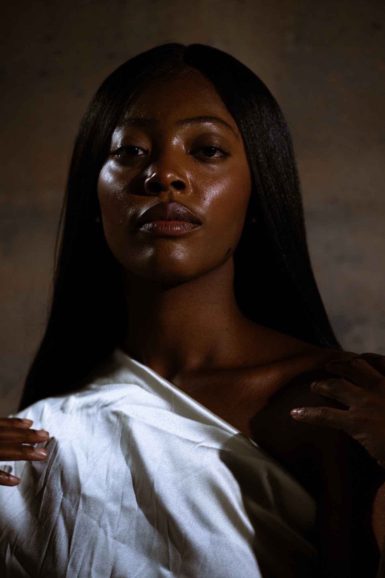 Portrait in white silk against a textured wall